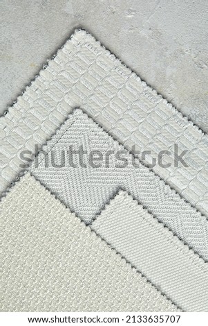 The background consists of several types of old colored tiles with different patterns on gray tone