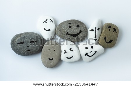 Tolerance and solidarity. Painted faces on different stones as a symbol of teamwork. International tolerance and emotional intelligence. Joint action and existence. One team called humanity.