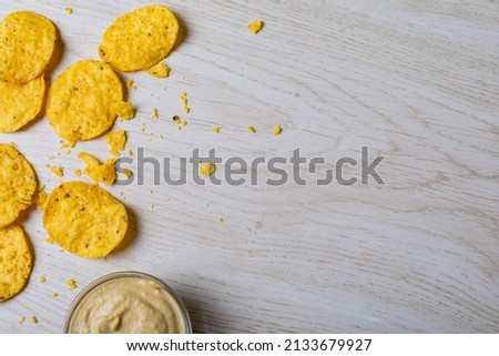 Overhead view of crunchy chips with dip in bowl on table with empty space. unaltered, copy space, unhealthy food, snack, dipping sauce, crunchy and savory food. Royalty-Free Stock Photo #2133679927