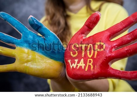 female hands one hand in the national color of ukraine blue yellow and the other hand red stop war.  Military conflict with Russia