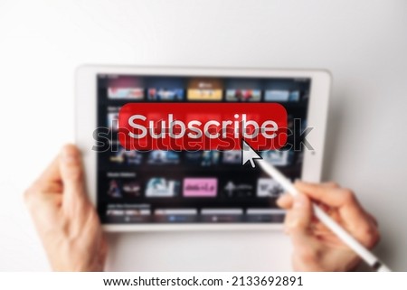 Subscription plan. Red online video subscribe button. Internet service on laptop digital tablet blured technology background. Visual contents concept. Social networking service