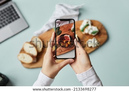 Top view of young woman taking aesthetic photo of food using smartphone in home studio, copy space Royalty-Free Stock Photo #2133698277