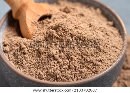 Close-up of flaxseed flour in a bowl. Side view, selective focus