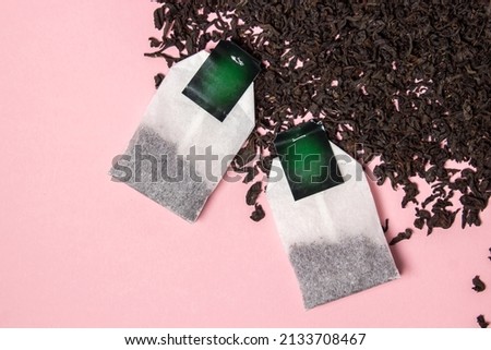Loose tea and tea bags on a pink background. Large leaf tea. There is room for copy space