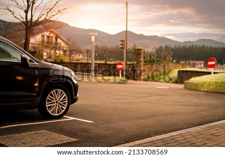 Black car parked at outdoor car parking lot of hotel in Spain. Parking lot with beautiful view of mountain. Road trip travel. Weather in the morning at outdoor car parking lot. Close to nature life.