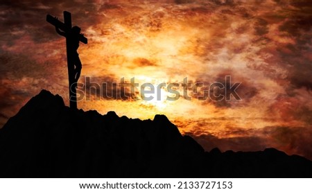 Jesus Christ crucified on the cross at Calvary hill with burning sky in background Royalty-Free Stock Photo #2133727153