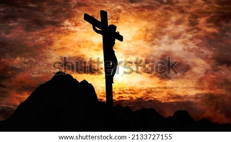 Jesus Christ crucified on the cross at Calvary hill with burning sky in background Royalty-Free Stock Photo #2133727155