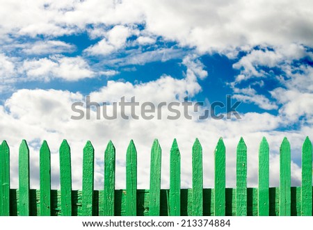 green wooden fence on a blue sky background