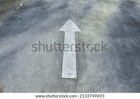 Road sign indicating White arrow sign on the street, Direction for traffic safety . white arrows pointing directions on gray asphalt floor. Your can Walking direction way . Symbol of crossroads 