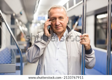 Mature man talking on phone in subway Royalty-Free Stock Photo #2133767911