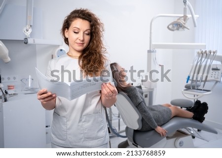 Portrait of a female dentist in a clinic. dental clinic and oral health concept. the doctor examines the client's card. copy space.