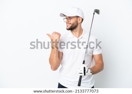 Handsome young man playing golf  isolated on white background pointing to the side to present a product