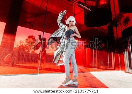 Young stylish woman in a futuristic image on a red background. High quality photo