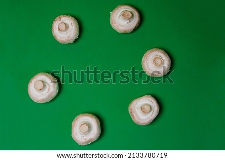 Champignon mushrooms on a green background.