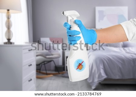 Woman with anti bed bug spray in bedroom, closeup