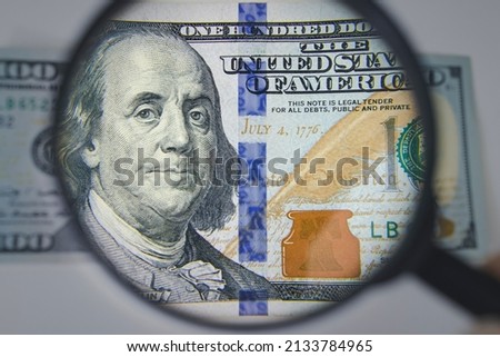 Finance and business. Closeup photo with a magnifying glass over 100 dollar banknotes