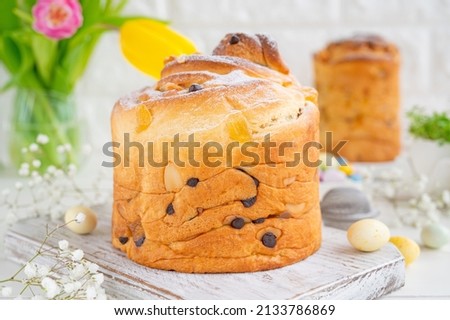 Easter composition. Traditional Russian and Ukrainian Easter cake - Cruffin, Kraffin or Kulich with chocolate and candied fruits on a white wooden background. Paska Easter Bread. Copy space.