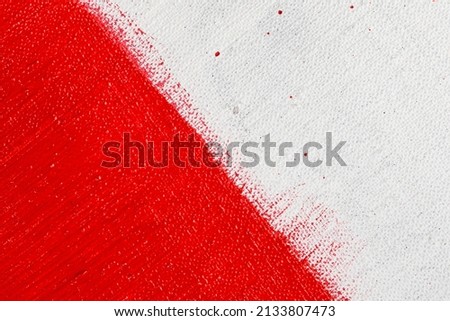 thick red bright acrylic paint applied unevenly on a light surface 