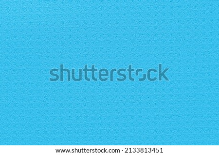 Porous blue background from a kitchen sponge. Blue background made of soft synthetic material with a chaotic close-up of pores. Free space for ads and text