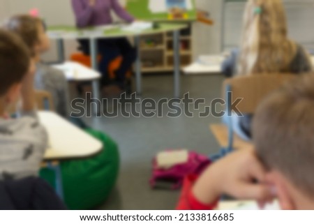 Blurred image of school children sitting in class at lesson background back to school 
