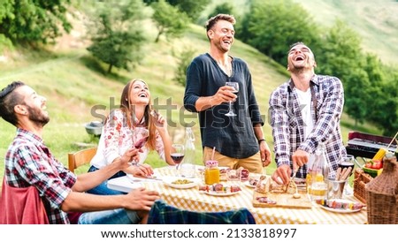 Happy friends group having fun drinking red wine at barbeque pic nic garden party - Young people eating tasty meal at farm house restaurant - Food and beverage life style concept on bright warm filter