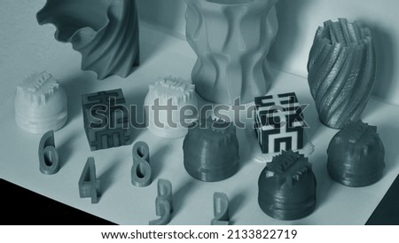 Models printed by 3d printer. Objects printed on 3d printer on table. Automatic three dimensional printer performs plastic modeling in laboratory. Progressive modern additive technology Royalty-Free Stock Photo #2133822719