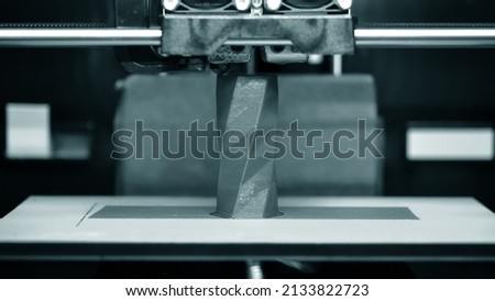 3D printer works and creates an object from hot molten plastic close-up. Automatic three dimensional 3d printer performs plastic blue colors modeling in laboratory. Royalty-Free Stock Photo #2133822723