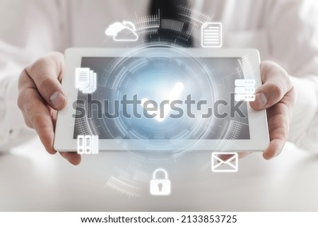 Businessman holding digital tablet with virtual document and mark correct sign