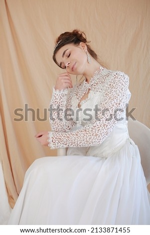 girl in a white wedding retro dress. wedding dress and hairstyle in the style of the 90's. Studio photo shoot in my mother's wedding dress. Bride photo shoot in the studio