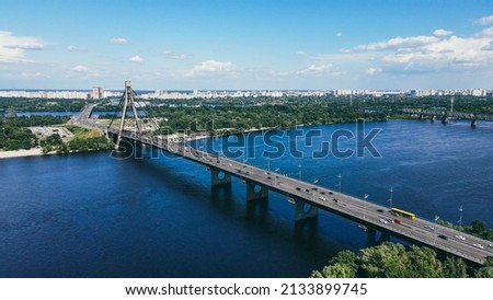 Traffic of cars on a large bridge over the river in a cityscape on a sunny day