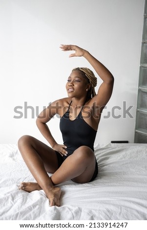 yoga pose in african woman's bedroom on bed