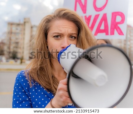 Beautiful and sad girl is talking on the megaphone, close up