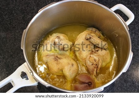 Chicken stew, onion and lemon broth, cooked in a pressure cooker. "kotopoulo lemonato" traditional Greek food. Top view, selective focus