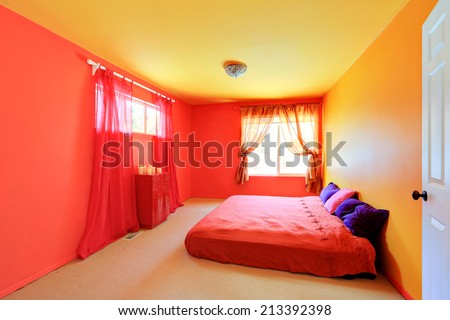 Bright vivid colors bedroom with red bed and dresser
