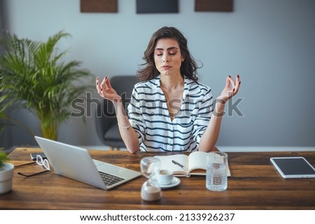 Calm female executive meditating taking break at work for mental balance, mindful businesswoman feeling relief and no stress doing yoga at work ignoring avoiding stressful job and paperwork in office Royalty-Free Stock Photo #2133926237