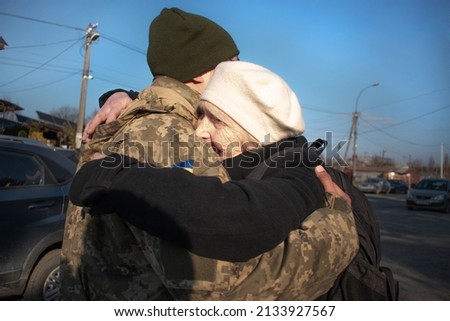 Elderly mother says goodbye to her military son. Mom hugs a Ukrainian soldier. Militarization. Ukrainian defender says goodbye to his family. Mobilization of Ukrainian men. War of Ukraine and Russia Royalty-Free Stock Photo #2133927567