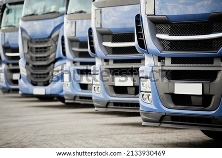 Fleet of commercial lorry trucks in row. Logistics and transportation service Royalty-Free Stock Photo #2133930469