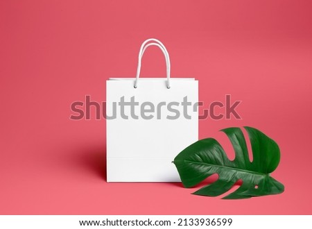 white gift bag on a yellow background with a palm leaf. Advertising package for the logo. Branding.