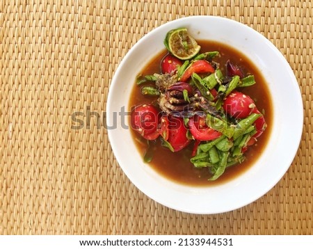 top view of papaya salad with long beans with fermented fish and crab on wood background, Thai food, food travel and cusine  Royalty-Free Stock Photo #2133944531