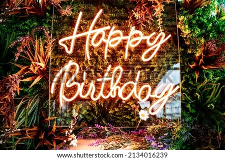 
happy birthday with neon lettering on green