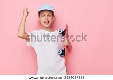 little girl cap in white t-shirt skateboard isolated background