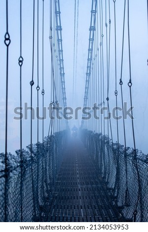 Beautiful suspension bridge in the early foggy morning.