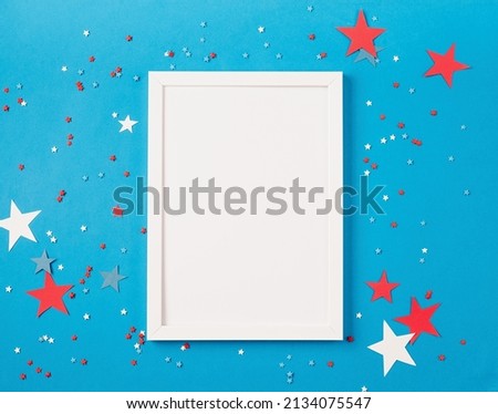 White frame for mockup design with USA independence day party element top view flat lay on solid blue background