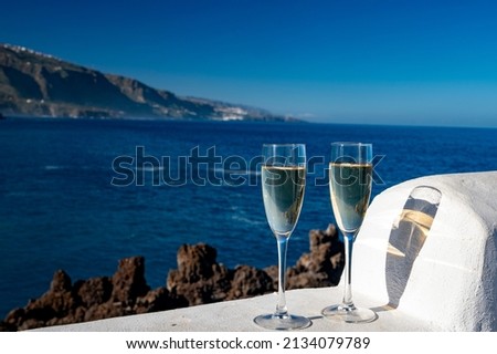 New year celebration with two glasses of champagne or Spanish cava sparkling wine and view on blue water of Atlantic ocean, Canary islands, winter tourists destination