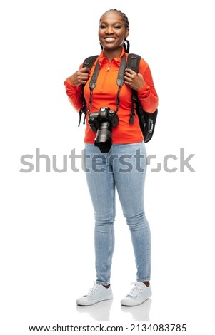 people, profession and photography concept - happy smiling woman photographer with digital camera and backpack over white background