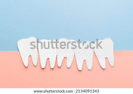 Crowding tooth cartoon made from paper. Problems resulting from dental crowding include gum disease, trouble chewing, toothache or jaw pain.