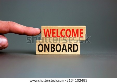Welcome onboard symbol. Concept words Welcome onboard on wooden blocks on a beautiful grey table grey background. Businessman hand. Business onboarding and welcome onboard concept, copy space.