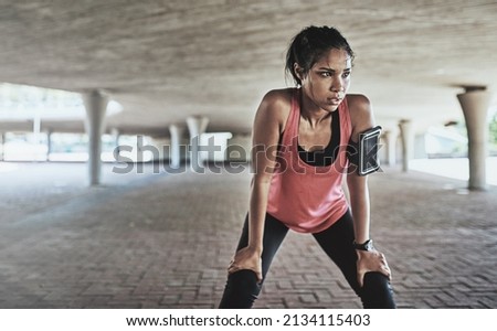 Youve gotta sweat for it. Shot of a sporty young woman taking a break while exercising outdoors. Royalty-Free Stock Photo #2134115403