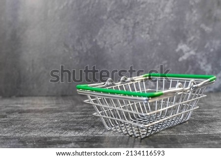 Empty metal shopping cart in a supermarket, side view