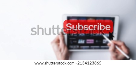 Subscribe button. Online video subscription red button. Internet service on laptop digital tablet blured banner background. Visual contents concept. Social networking service